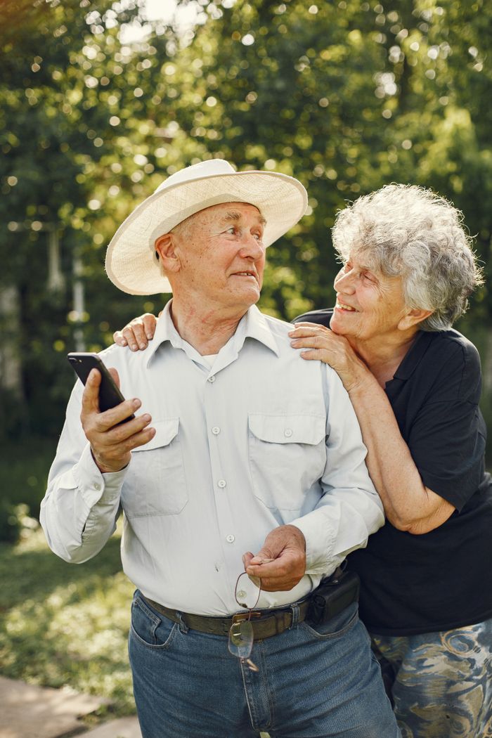 Happy senior couple embracing and enjoying a sunny day in the garden, exuding warmth and affection.