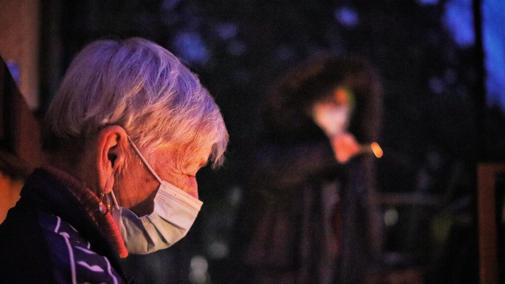 Vieille femme avec un masque chirurgicale la nuit
